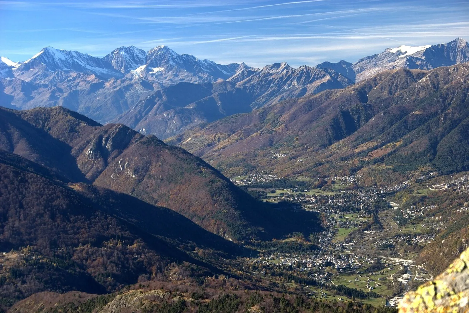 La Valle Vigezzo vista dall'alto in autunno, con i paesi sul fondovalle e le Alpi innevate sullo sfondo