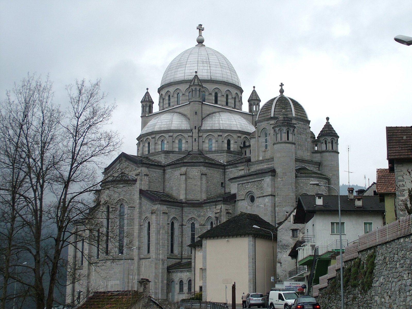 La basilica della Madonna del Sangue a Re vista dalla strada, con la grande cupola e le torrette in pietra sotto un cielo nuvoloso